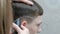 A close-up of the hands of a hairdresser who shaves the picture on the head of a young man with an electric clipper. A teenager in