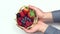 Close up of hands holding basket with forest fruit berries
