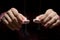 Close up hands holding a candle in the dark above the wooden surface f