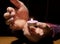 Close up hands holding a candle in the dark above the wooden surface f