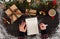 Close up of hands holding empty wishlist on wooden table with Christmas decoration.