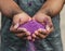 Close-up of hands holding purple powder