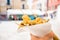 Close up of hands holding street food consisting in fried fish inside a paper cone in venice during sunny summer day