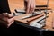 Close-up on hands inserting a whetstone into a manual sharpener machine