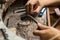 Close-up of the hands of a jeweler making repairs to a gold bracelet