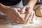 close-up of hands, kneading dough into smooth and supple roll