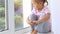 Close up of hands on knees of cute little girl sitting on windowsill of window.