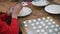 Close-up of hands making balls of white dough.