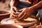 Close-up of hands making clay pots