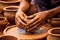 Close-up of hands making clay pots