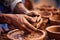 Close-up of hands making clay pots