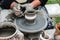 Close-up of hands making pottery from clay on a wheel.