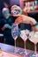 Close up of hands of male bartender pouring, mixing ingredients while making classic cocktail alcoholic drink at the bar