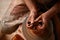 Close-up hands of a male potter in apron squizing wrong bowl from clay, selective focus