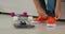 Close-up hands of a male skateboarder tying shoelace in orange shoes at home.