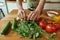 Close up of hands of man, cook serving traditional soup, using basil leaves for decorating the meal. Cooking at home