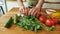 Close up of hands of man, cook serving traditional soup, using basil leaves for decorating the meal. Cooking at home