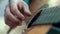 Close up hands man playing music on strings acoustic guitar