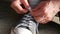 Close-up hands of man tying shoelace