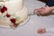 Close Up of Hands of Married Cutting the Wedding Pie on Blur Background