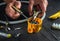 Close-up of hands of a master electrician during work. Installing a cable or wire to yellow junction box. Free advertising space