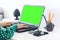 Close-up of hands middle-aged woman typing on keyboard green screen laptop, concrete holder with pencils and pens, notebook,