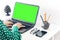 Close-up of hands middle-aged woman typing on keyboard green screen laptop, concrete holder with pencils and pens, notebook,