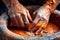 close-up of hands molding wet clay on potters wheel