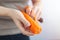 Close up of hands peeling cutting orange carrot with a knife. Healthy food preparation concept