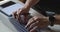 Close-up of hands with pen of unrecognizable businessman typing on laptop computer at the desk. Concept of remote home