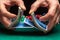 Close-up hands of a person-dealer or croupier shuffling poker cards in a poker club on the background of a table, chips. Poker