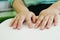 Close-up hands of person woman with blindness disability using fingers reading Braille book studying in library. Braille is a