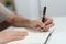 Close up hands of person writing note to notebook pages