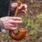 A close-up of the hands of a piper playing the bagpipe on the nature background.