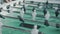 Close-up of hands playing foosball game indoors while people are relaxing at work