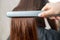 Close up hands of professional hairdresser beauty salon, straighteners curling female hair