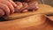 Close-up of hands putting three raw marinated quails on the wooden board