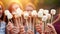 Close up of hands roasting marshmallows on stick in the warmth of an evening campfire