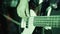 Close up of the hands of a rock guitarist and a bass guitar. Young professional bass player playing guitar solo. The