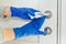 Close up of hands in rubber gloves disinfecting door handle
