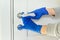 Close up of hands in rubber gloves disinfecting door handle