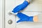 Close up of hands in rubber gloves disinfecting door handle