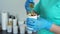 Close - up of hands in rubber gloves open a jar of sugar for hair removal by sugaring