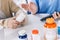 Close up hands of a senior woman holding a medical bottle and asking information from the nurse before administering medication.