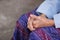 Close-up of hands senior woman joined together while sitting on a chair in a garden. Focus on hands wrinkled skin. Concept of aged