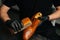 Close-up hands of shoemaker in black gloves polishing light brown leather shoes with brush during restoration working.