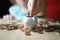 Close-up of hands of small child manipulate with metal coins, kid counts, puts euro union money in white piggy bank, concept of