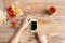 Close up of hands with smartphone food on table