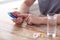 Close up of hands with smartphone, pills and water