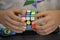 Close-up of hands solving a Rubik`s Cube. Color puzzle.